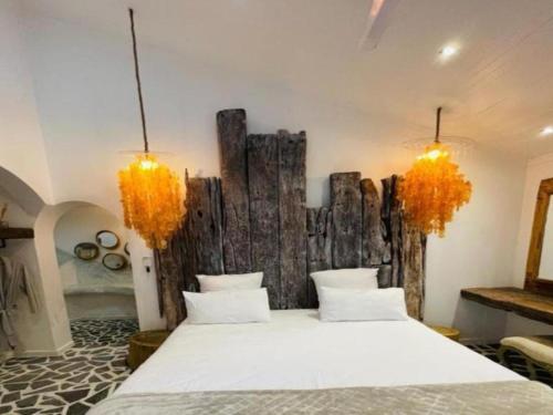 ein Schlafzimmer mit einem Bett und einer Holzwand in der Unterkunft Little Mykonos in Johannesburg