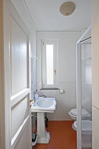 a white bathroom with a sink and a toilet at Verdelia in Giffoni Valle Piana