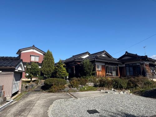 a group of houses with a gravel driveway at ゲストハウス あめりか和 in Namerikawa