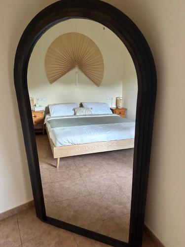 a bedroom with a bed with a large mirror at Cortijo Chupito in Yunquera