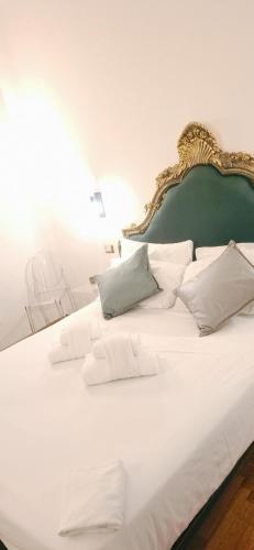 ein großes weißes Bett mit grünem Kopfteil und weißen Kissen in der Unterkunft DCBoutiqueHotel in Rom