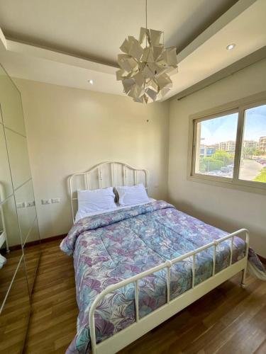 een slaapkamer met een bed en een kroonluchter bij Cozy crystal lounge in Sheikh Zayed