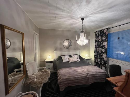 una camera con letto, specchio e lampadario a braccio di Apartment Northernlightroad a Rovaniemi