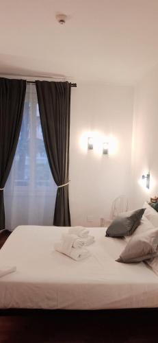 ein Schlafzimmer mit einem großen weißen Bett und einem Fenster in der Unterkunft DCBoutiqueHotel in Rom