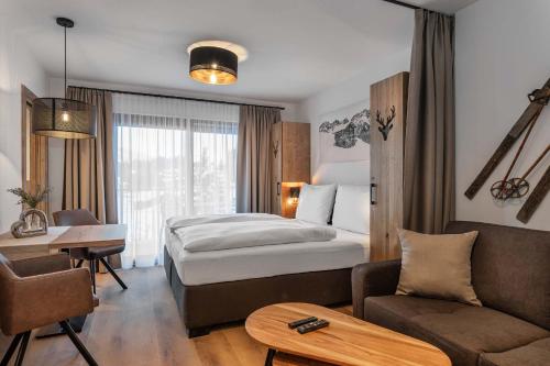una habitación de hotel con una cama y un escritorio en AlpenParks Hotel & Apartment Taxacher, en Kirchberg in Tirol