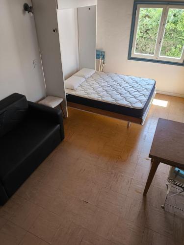 a room with a couch and a bed in it at Casita funcional en Claromeco in Balneario Claromecó