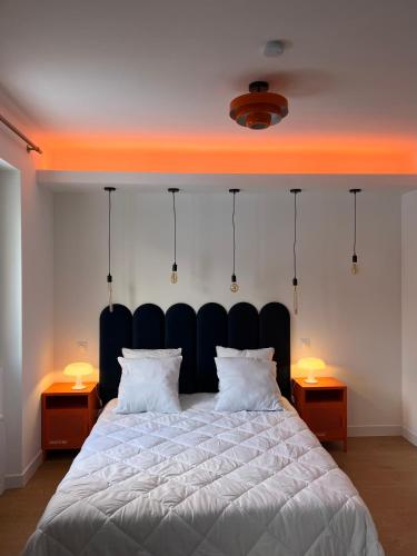 ein Schlafzimmer mit einem großen weißen Bett mit zwei Lampen in der Unterkunft Les Couleurs du Lac in Gérardmer