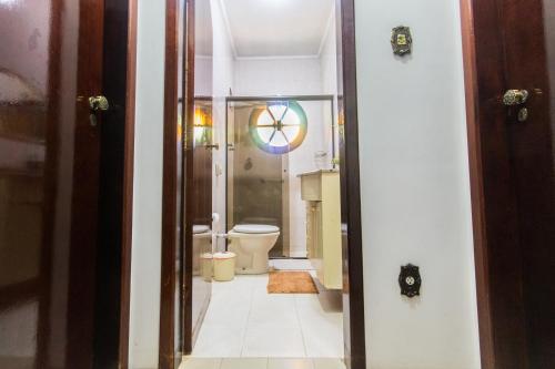 a bathroom with a toilet and a glass shower at Villa Bem Querer - Camomila in Mairiporã