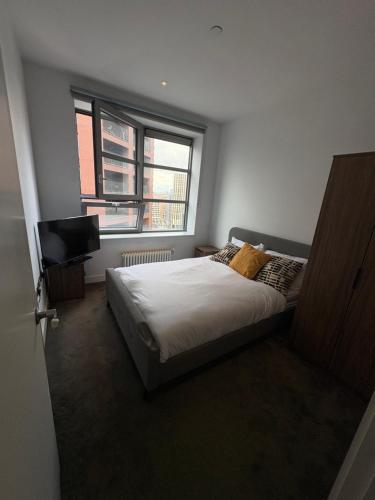um quarto com uma cama e uma televisão em Cozy and Spacious Central London Stay in Canary Wharf with a City View & a Private Bathroom for Luxury Comfort at a Great Value em Londres