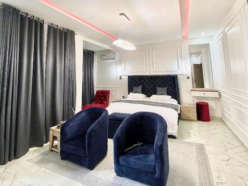 a bedroom with two blue chairs and a bed at House 8 in Lekki