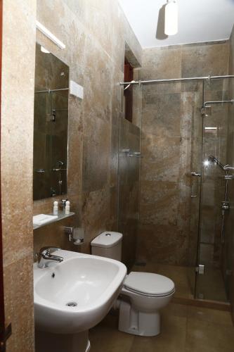 a bathroom with a sink and a toilet and a shower at Cirute' Talwatte, Kandy in Kandy