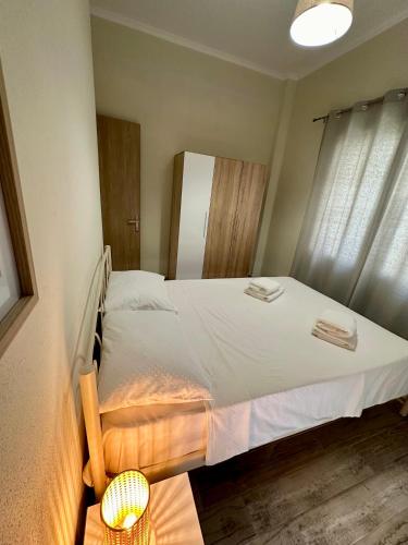 a bedroom with a large white bed with a window at ESTIA Apollon in Drama