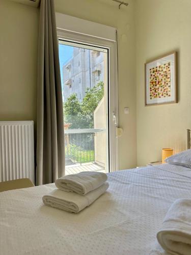 a bedroom with a bed and a large window at ESTIA Apollon in Drama