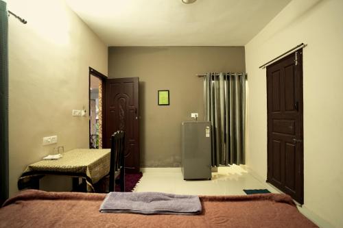 a bedroom with a bed and a refrigerator in it at Dean Dale Cottages in Thekkady