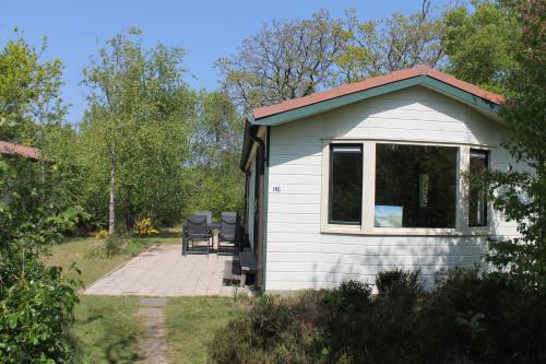 a white shed with a patio in a garden at Heitje 166 in Den Burg