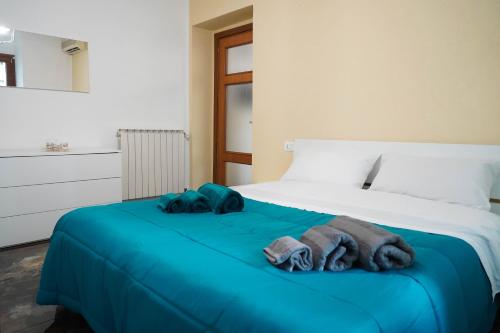a bed with blue sheets and towels on it at Calabria is Home in Crotone