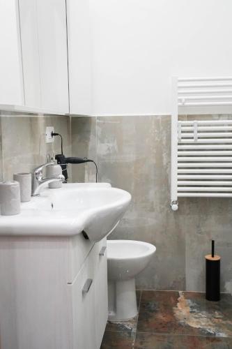 a white bathroom with a sink and a toilet at Calabria is Home in Crotone