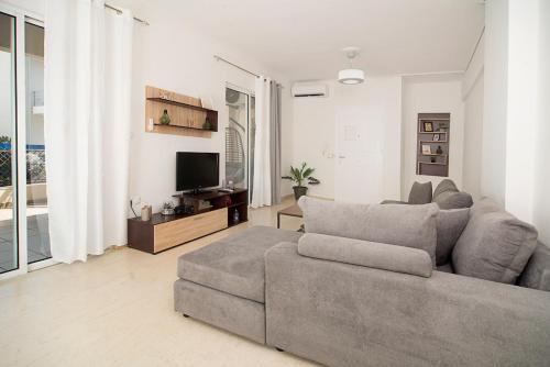 ein Wohnzimmer mit Sofa und Fernseher in der Unterkunft Ioulia in Kalamata