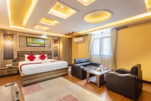 a hotel room with a bed and two chairs at Hotel Airport Deepshree in Kathmandu
