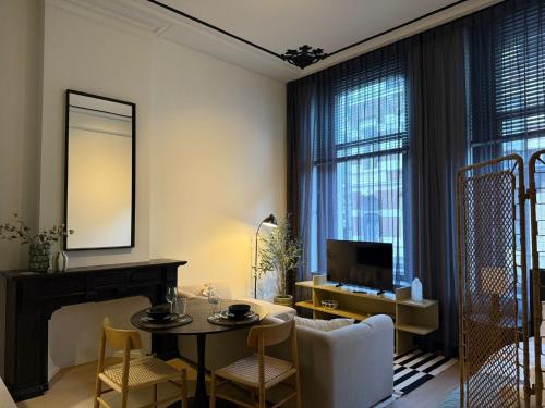 a living room with a table and a tv at Naest - Authentic Escapes City House Nijmegen in Nijmegen