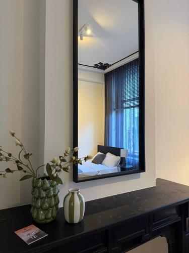 a mirror on a wall with a bed in a room at Naest - Authentic Escapes City House Nijmegen in Nijmegen