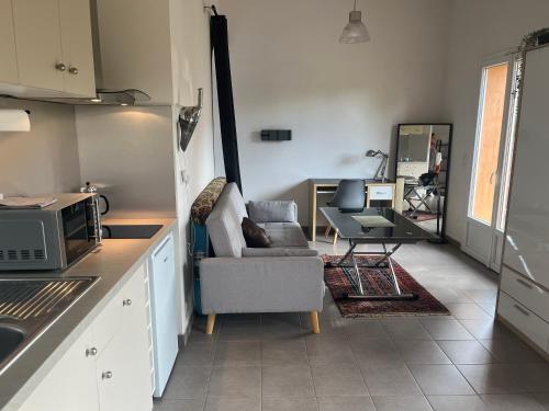 una cucina con divano e sedia in una camera di Charmante petite maison provençale a Grasse