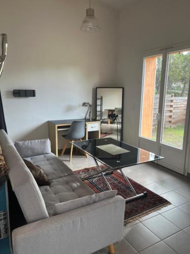 un soggiorno con un divano e un tavolo di vetro di Charmante petite maison provençale a Grasse