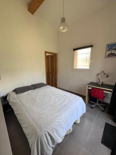 a bedroom with a bed and a desk at Charmante petite maison provençale in Grasse