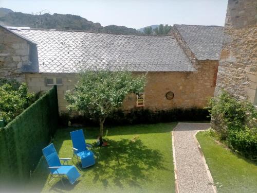two blue chairs in the yard of a house at Bajo los nidos 2 in San Emiliano