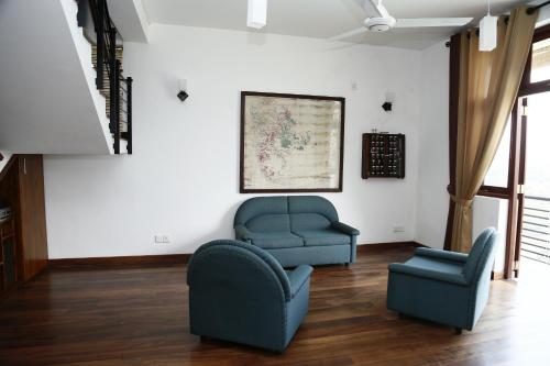 a living room with two chairs and a couch at Cirute' Talwatte, Kandy in Kandy