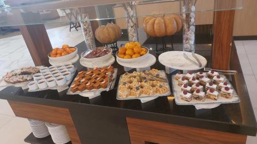 タシュケントにあるApart Hotel Istaravshanのさまざまな種類のデザートとカボチャが並ぶビュッフェ