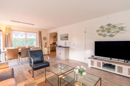 ein Wohnzimmer mit einem großen Flachbildfernseher in der Unterkunft Villapark Kamperfoelie 91 in De Koog