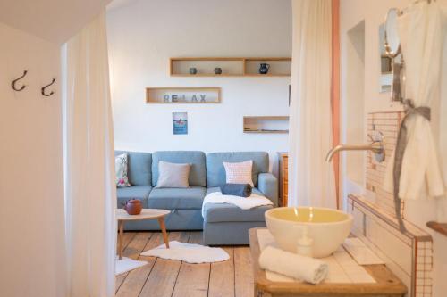 Una sala de estar con un sofá azul y una mesa. en MOOKI Country Apartment, en Villach