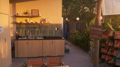 - une cuisine extérieure avec 2 chaises et un comptoir dans l'établissement Hẹ Stay, à Hue
