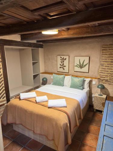a bedroom with a large bed with towels on it at La Casona del Asno in Alcalá de Henares