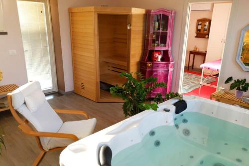 een bad in een kamer met een stoel bij Appartamento Lavanda Seaside and Pool in La Caduta