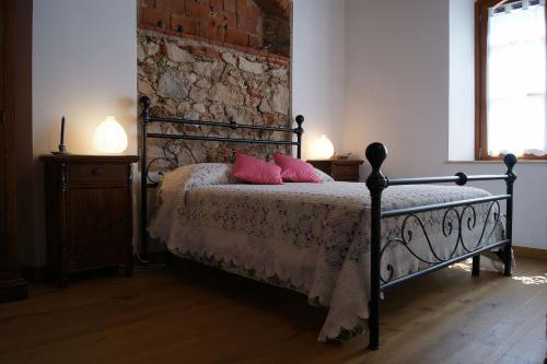 een slaapkamer met een bed met roze kussens erop bij Appartamento Lavanda Seaside and Pool in La Caduta