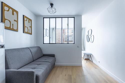 a living room with a couch and a window at Comfortable Apartment , Porte-Dorée District, Paris in Paris