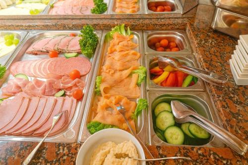 a table with trays of different types of food at Hotel Rheinland in Bad Orb