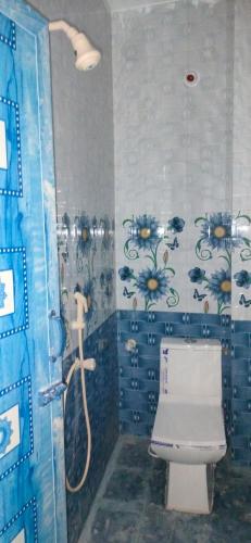 a bathroom with a toilet and a shower with blue tiles at Guru Rooms in Tiruvannāmalai