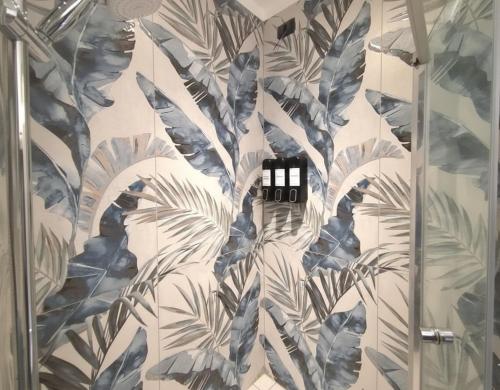 瓦雷泽BB Cadore casa vacanze的浴室设有蓝色和白色壁纸淋浴。