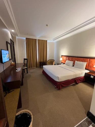 Ένα ή περισσότερα κρεβάτια σε δωμάτιο στο Grand Q Hotel Gorontalo