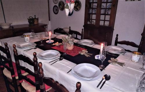 einen Tisch mit weißen Tellern und Kerzen darauf in der Unterkunft Casa da Bonança Ofir in Fão