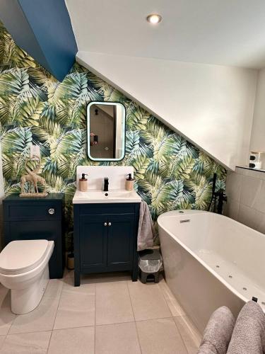 a bathroom with a sink and a tub and a toilet at Jasmine Cottage Audlem in Audlem