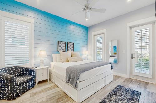 une chambre avec un lit blanc et un mur bleu dans l'établissement Paradise Found at Palmilla Beach, à Port Aransas