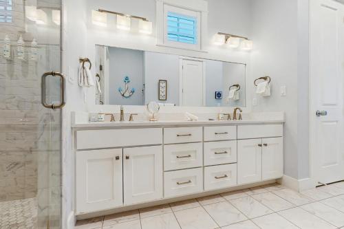 une salle de bain blanche avec lavabo et douche dans l'établissement Paradise Found at Palmilla Beach, à Port Aransas