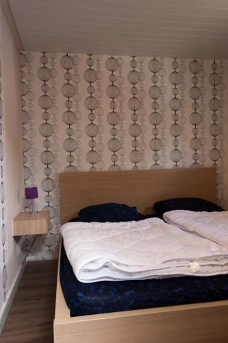 a bedroom with a bed with a headboard and a curtain at uterste-coogh 102 in Den Burg