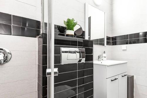 Baño en blanco y negro con lavabo y espejo en 2Bedroom Suite 7 with shelter, en Tel Aviv