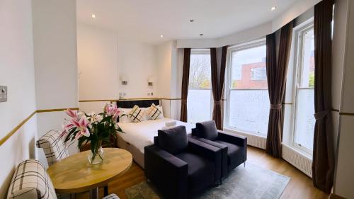 a hotel room with a bed and a table and chairs at Osborne Aparthotel in Eastbourne