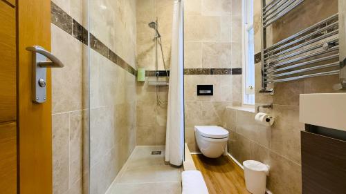a bathroom with a toilet and a shower at Osborne Aparthotel in Eastbourne
